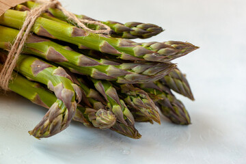 Bunch of fresh asparagus diagonal on the light blue background