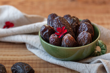 Bowl of date fruits on a wooden table