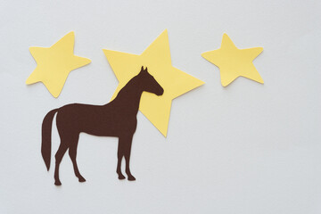 horse and stars (cut paper glyph dingbat shapes) on blank paper