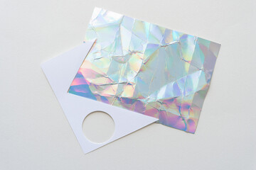 crumpled iridescent paper card and white paper shape with circle cutout