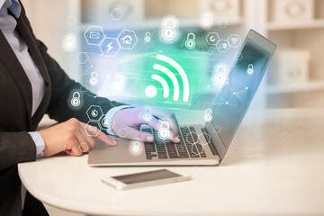 Hands working on laptop with digital icons