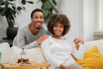Obraz premium Happy black husband and wife drinking tea at home