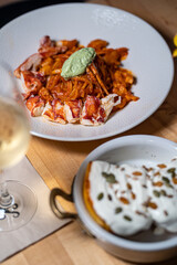 Spaghetti Frutti di Mare on a table set with glass of wine