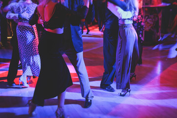 Couples dancing traditional latin argentinian dance milonga in the ballroom on a festival, tango...
