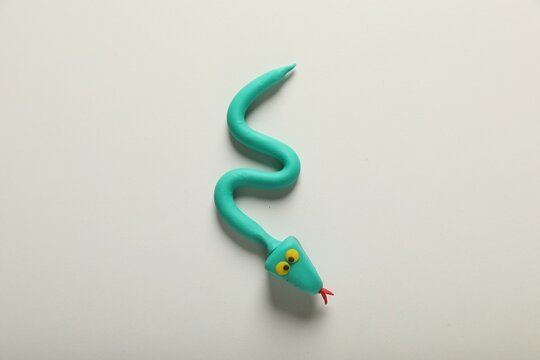 Turquoise plasticine snake isolated on white, top view
