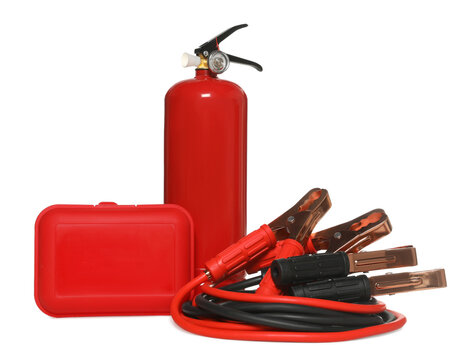 Red fire extinguisher, first aid kit and battery jumper cables on white background. Car safety