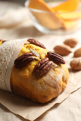 Delicious pumpkin bread with pecan nuts on tablecloth, closeup