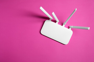 New white Wi-Fi router on pink background, top view. Space for text - obrazy, fototapety, plakaty