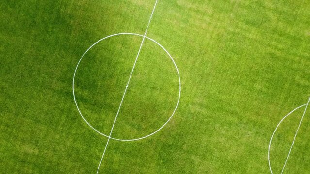 Vuelo de drone, sobre cancha de futbol con jugadores entrenando a pleno sol, al fondo un campo de agave.