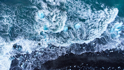 Melting Arctic Ice in Ocean Water, Blue Glacier Ice with Snow on Black Volcanic Beach in Iceland....
