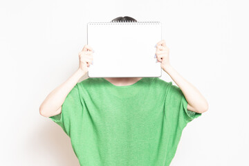 小さいスケッチブックを見せる若い女性