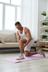 Man sports pain in the side and leg during a workout at home, pumped up man sports, the concept of health without injuries and sprains muscles and ligaments of the body