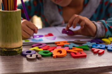 English alphabet made of square wooden tiles with the English alphabet scattered on hand. The...