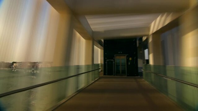 Puente a gran velocidad  en modo hyperlapse con grandes ventanas verdes llegando a un elevador 