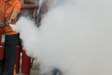 Showing how to use a fire extinguisher on a training fire for employees industry.Fire fighter...