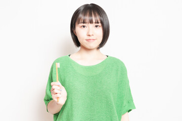 歯ブラシを手に持っている若い女性