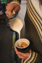Fototapeta na wymiar Barista sirviendo taza de café mediante el método de arte latte