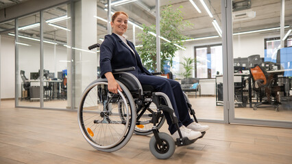 Fototapeta na wymiar Caucasian woman wheelchair in open space office.