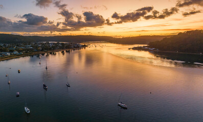 Aerial sunrise waterscape with boats and scattered clouds