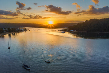 Aerial sunrise waterscape with boats and scattered clouds