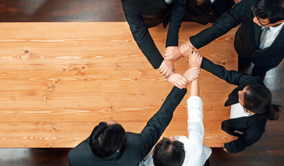 Top view cohesive group of business people join hands stack together, form circle over meeting...