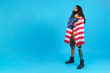 Man standing with a prosthetic leg and a north america national flag