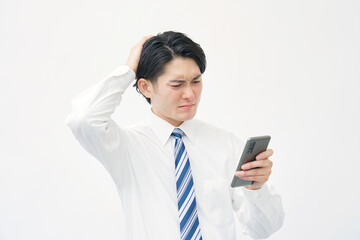 スマホを持って悩むビジネスマン　白背景