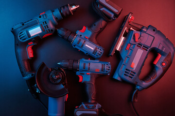 Set of new power tools isolated on a black background, drill, puncher, electric saw, jigsaw,...