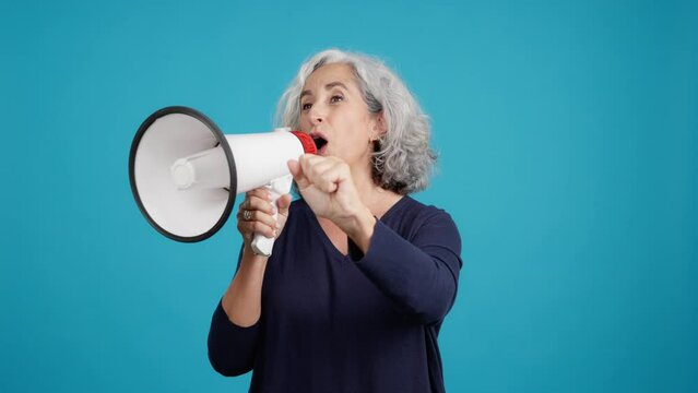 Mature Woman Raising The Fist And Protesting With A Loudspeaker