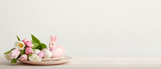 Flowers, Easter eggs and toy bunny on light background with space for text