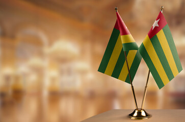 Small flags of the Togo on an abstract blurry background