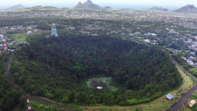 Flying drone 4K video over Trou aux Cerfs dormant volcano crater covered exotic trees and plants. Mauritius island losted in Indian ocean.