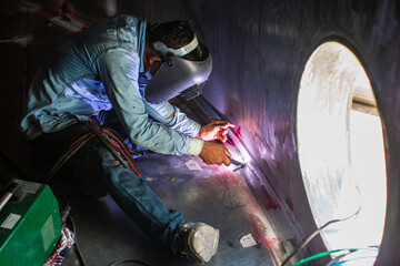 Welding  arc argon worker male repaired metal is welding sparks industrial construction tank