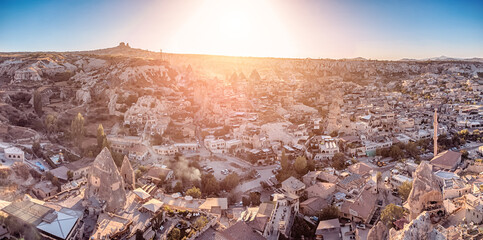 Aerial view of Hotels and houses carved into the rocks at sunset in Cappadocia - one of the wonders of the world in Turkey.