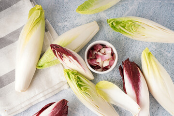 Composition with whole and cut endive on light background - obrazy, fototapety, plakaty