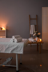 Interior of dark spa salon with couch, table and ladder