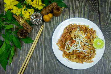 my favorite food is Pad Thai vietnamese sausage topping bean sprout and slice of lime serve hot on the dark table.