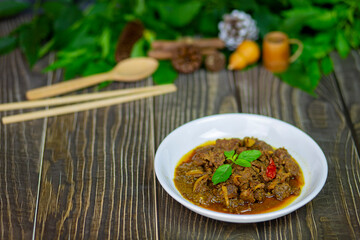 Lunch beef stewed ginger with chinese spices have taste is similar to massaman curry and serve on the dark wooden table.