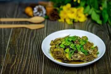 Herbs chicken with giblets steam topping coriander and spring onion serve hot on the dining table.