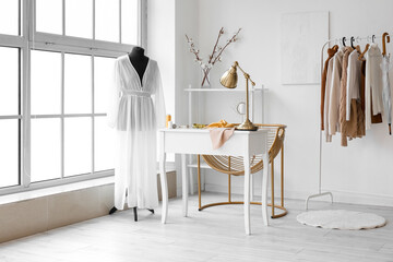 Interior of fashion designer's studio with mannequin, workplace and clothes