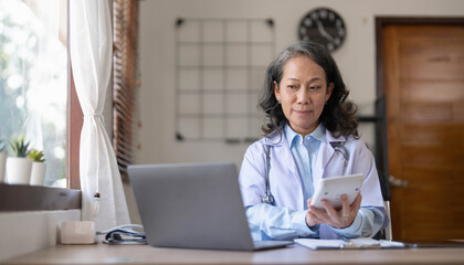 Confident female doctor sitting at office desk, health care and prevention concept. Portrait of friendly physician woman. Medicine concept. Portrait Of Smiling Female Doctor