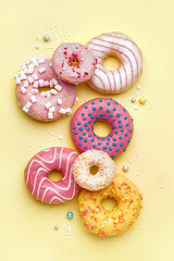 Tasty glazed donuts on yellow background