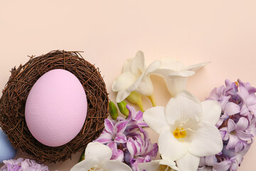 Composition with beautiful spring flowers and Easter eggs on color background, closeup