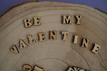 Text wooden blocks spelling the word be my valentine on wood background