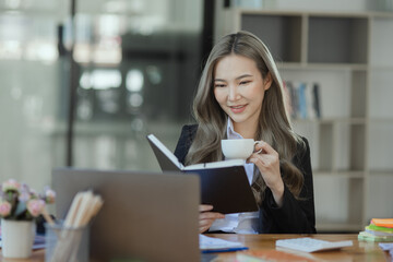 Cheerful asian businesswoman working at table office. 