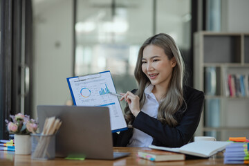 Obraz premium Cheerful asian businesswoman working at table office. 