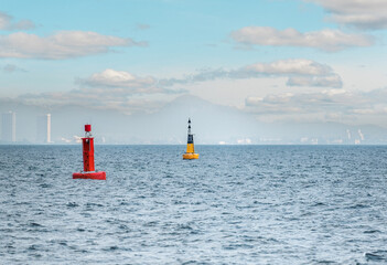 Floating red navigational buoy on blue sea. Marine signal buoy. Navigational Buoy marking a shipping channel - obrazy, fototapety, plakaty