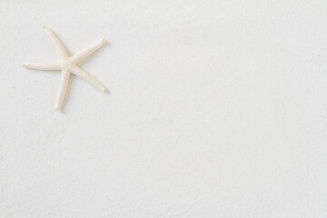 Fototapeta na wymiar Top view of starfish on white sand background.