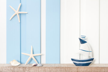 Summer sea decoration background - Front view of sailboat , starfish and seashell on wooden shelf...