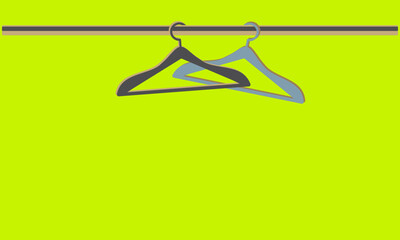 A pair of empty coat hangers on a pipe hanger. Bright light green background with hangers and copy space